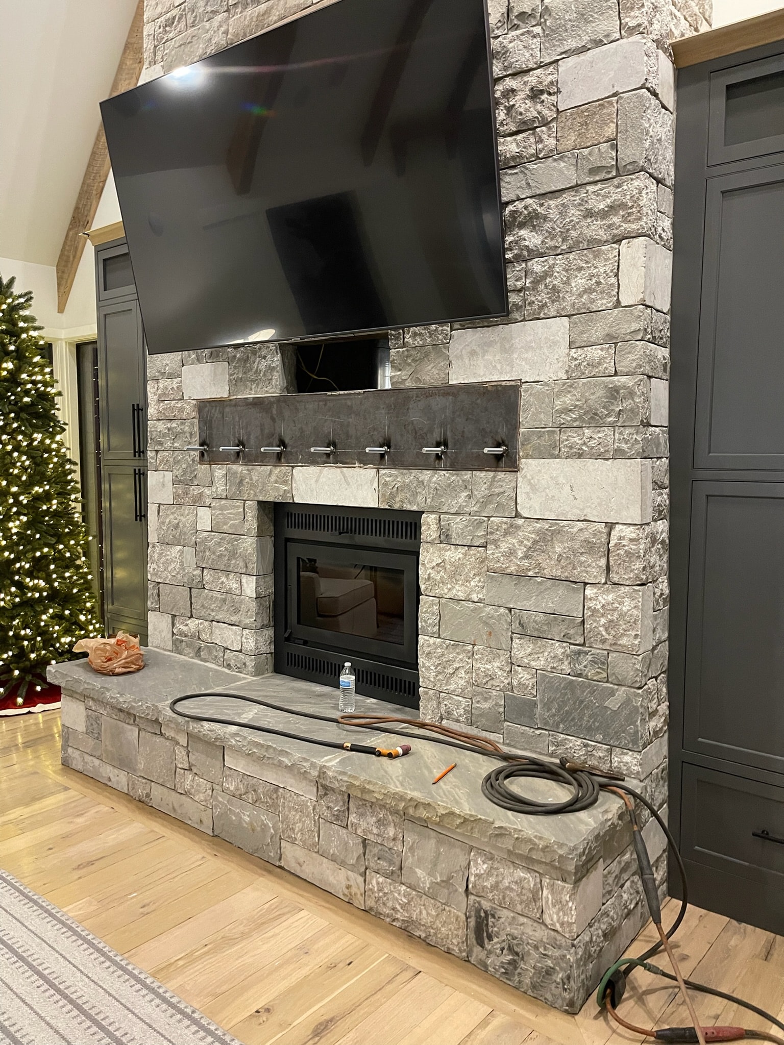Custom steel fireplace mantel and media-wall metalwork in a finished home