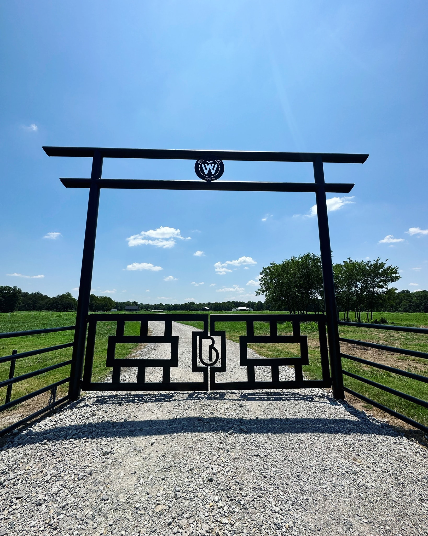Decorative black steel ranch entrance gate with geometric metalwork