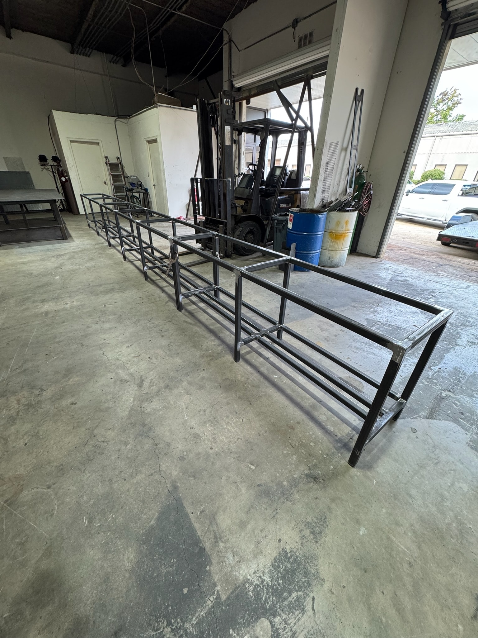 Custom steel fabrication frames staged inside the Claudio Welding shop