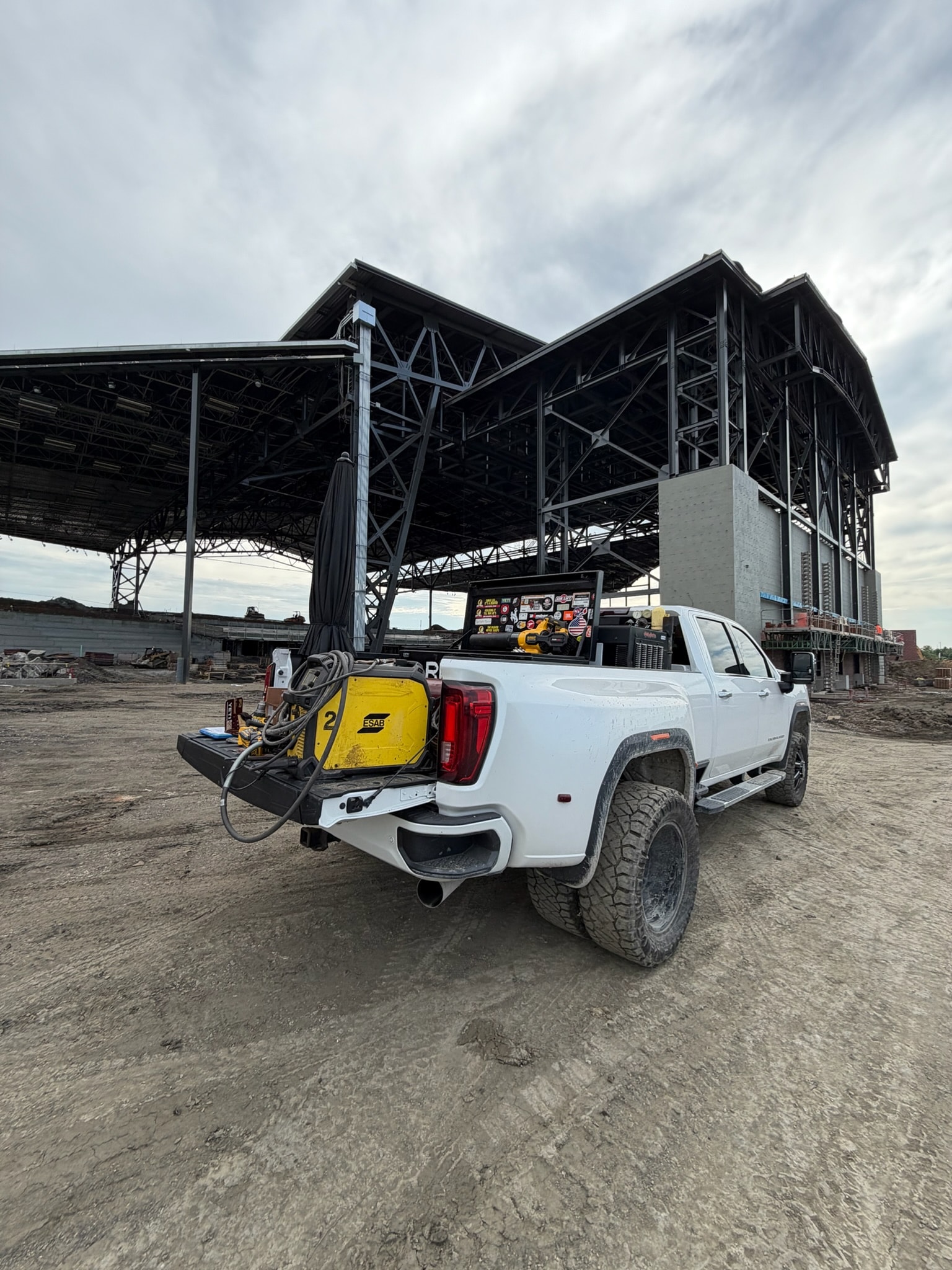 Mobile welding truck staged beside a large structural steel project