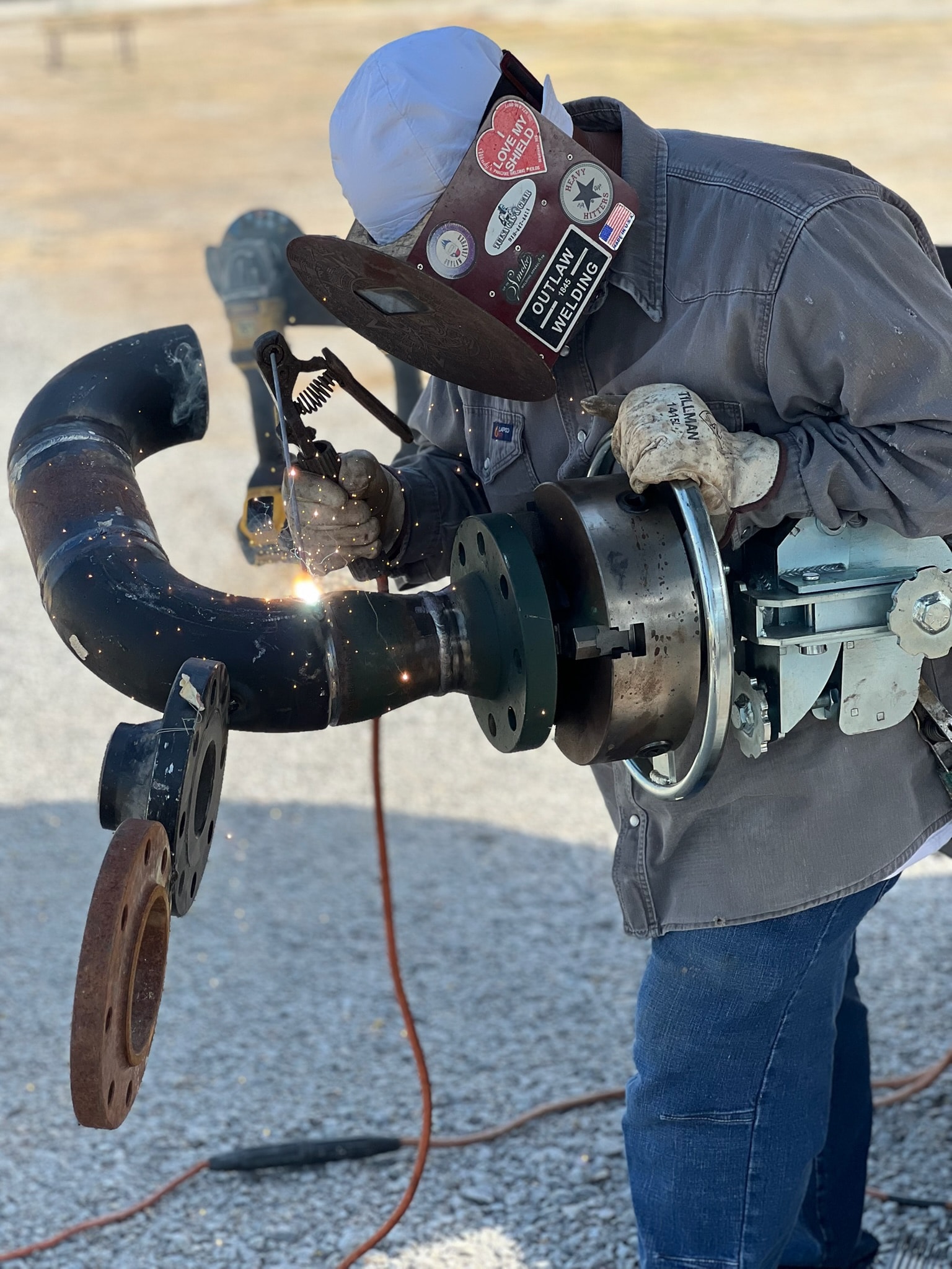 Field welder completing a large industrial pipe connection outdoors