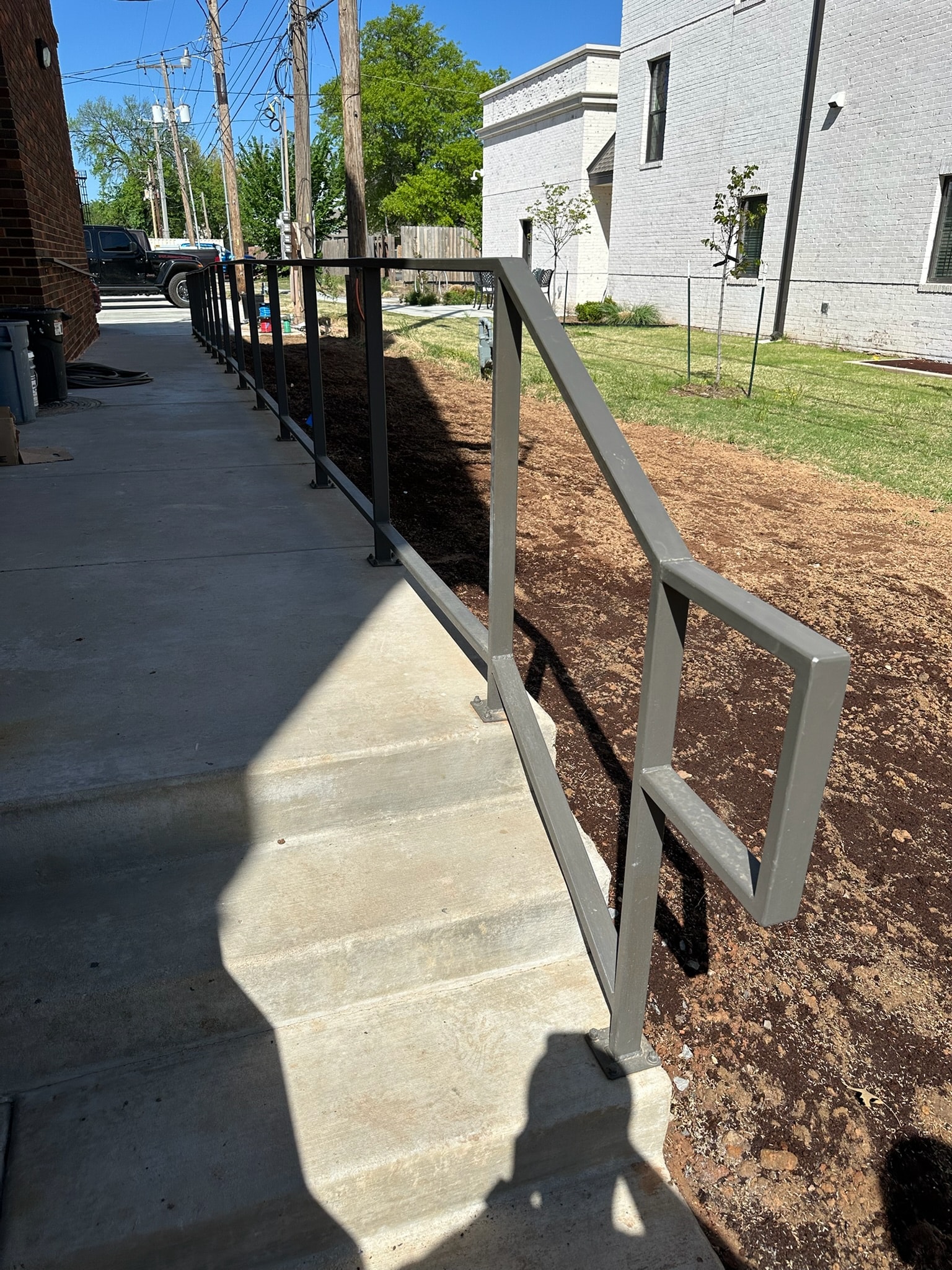 Modern steel walkway handrail installed beside a residential building