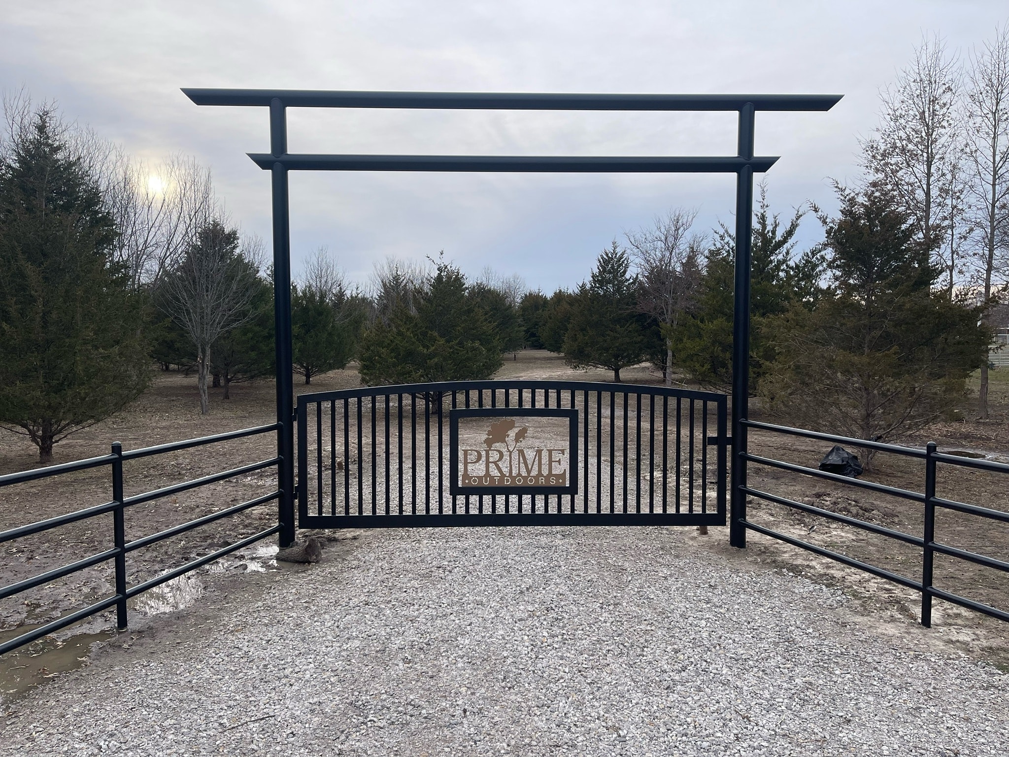 Custom black entrance gate and fencing installed at Prime Outdoors
