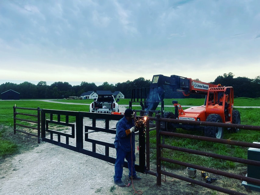 Field welding a custom ranch gate at a rural property