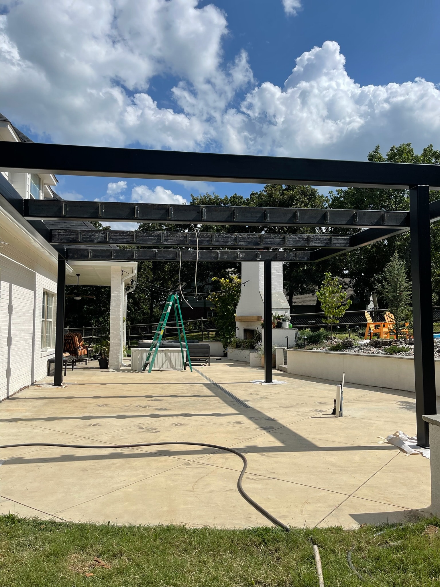 Custom black steel pergola frame installed over a residential patio