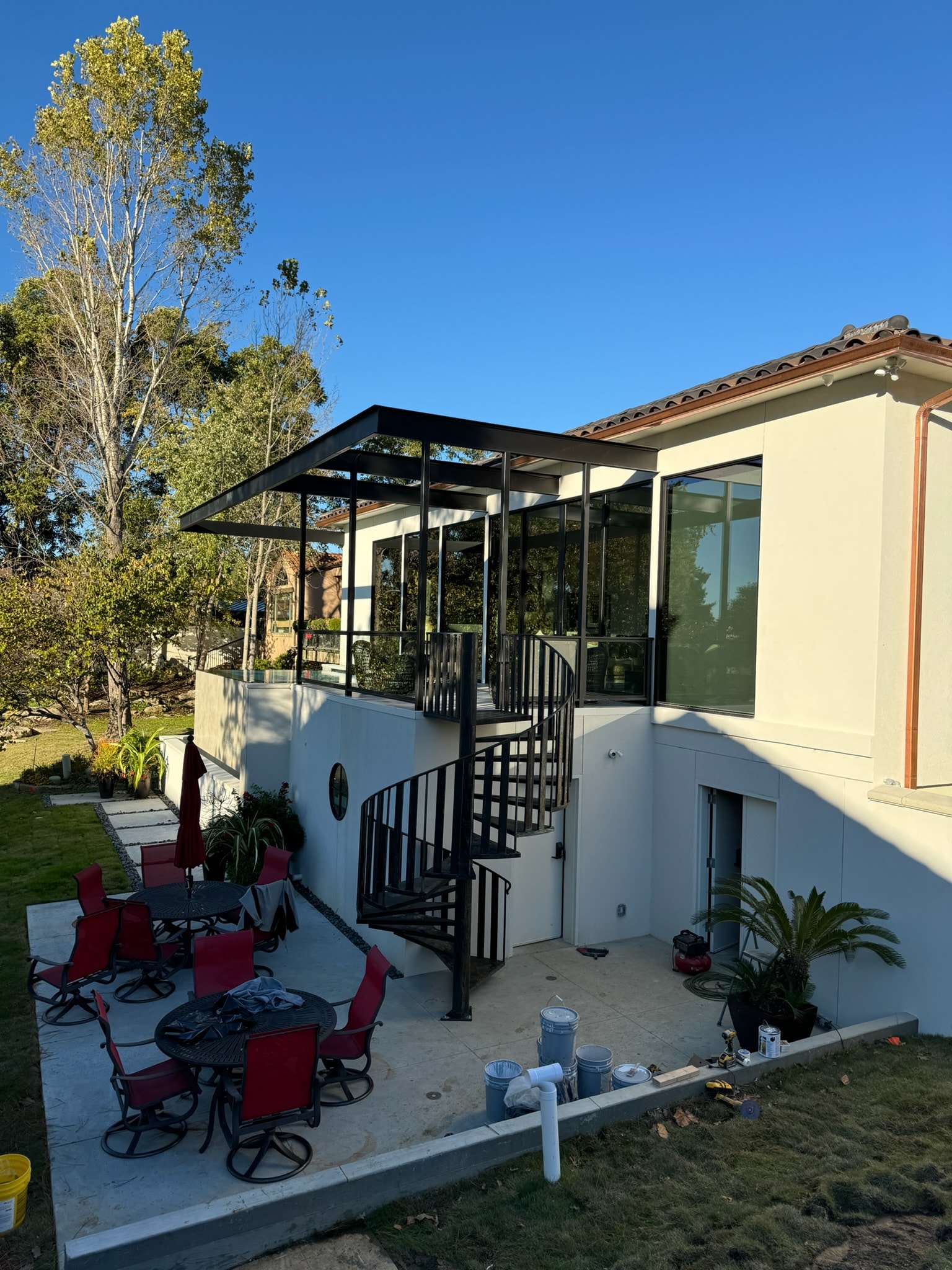 Custom spiral staircase and steel patio enclosure at a modern residence