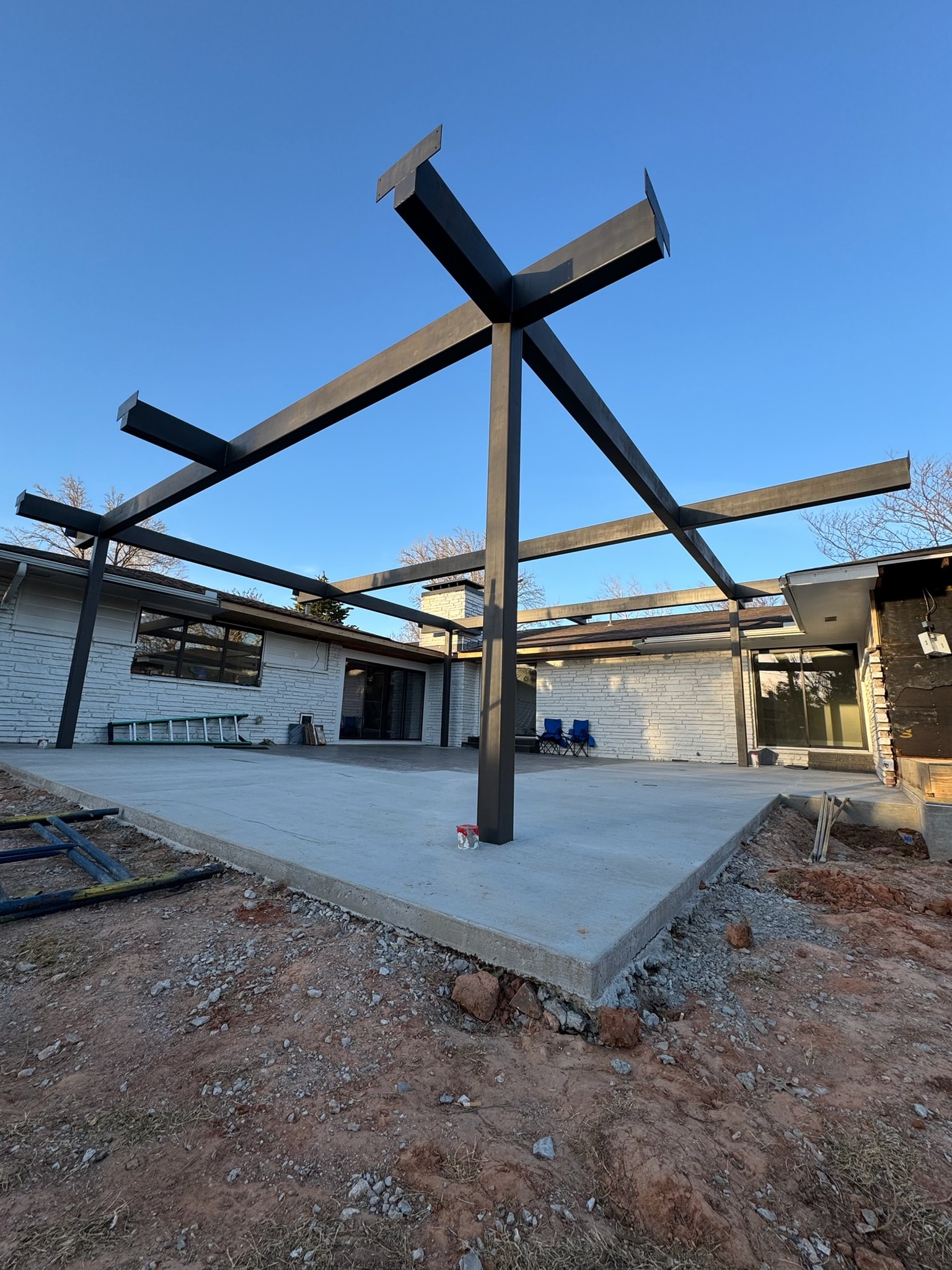 Residential steel pergola frame installed over a concrete patio