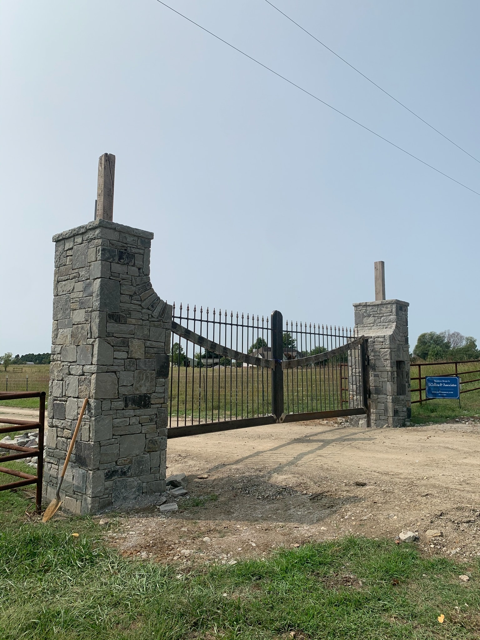 Stone-and-iron entrance gate installed at a rural property