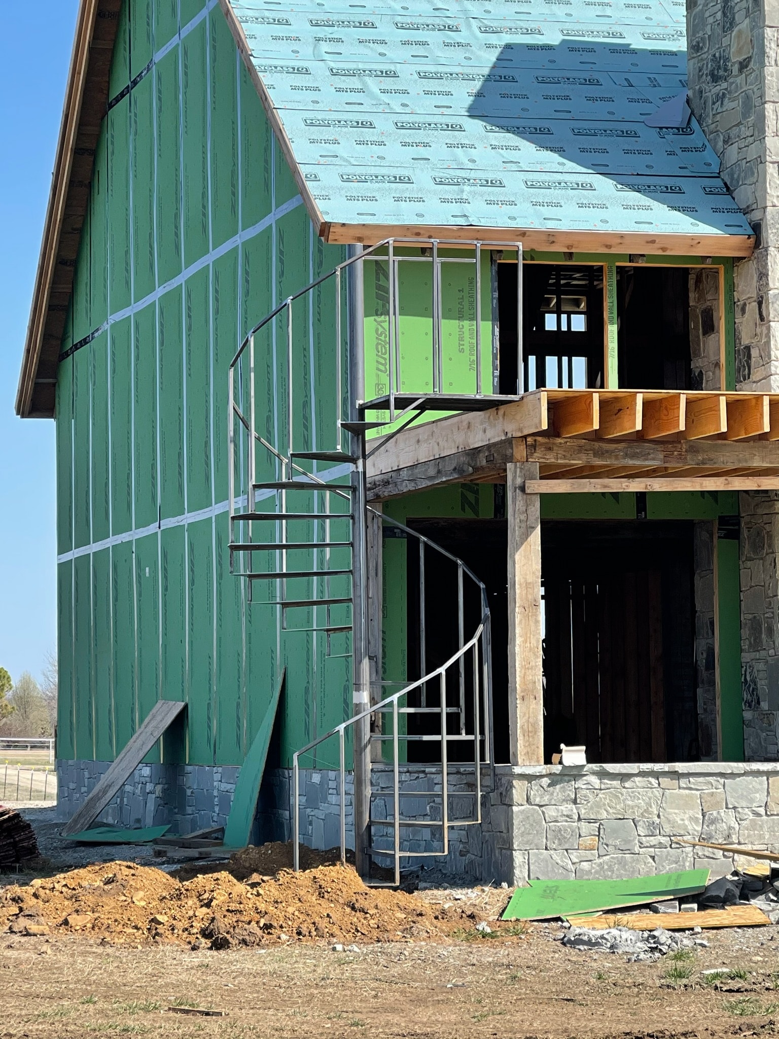 Stone and wood building exterior under construction with steel details