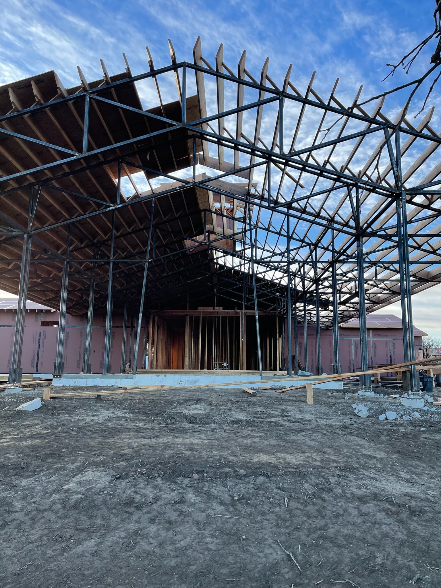Large structural steel roof frame installed at an active construction site